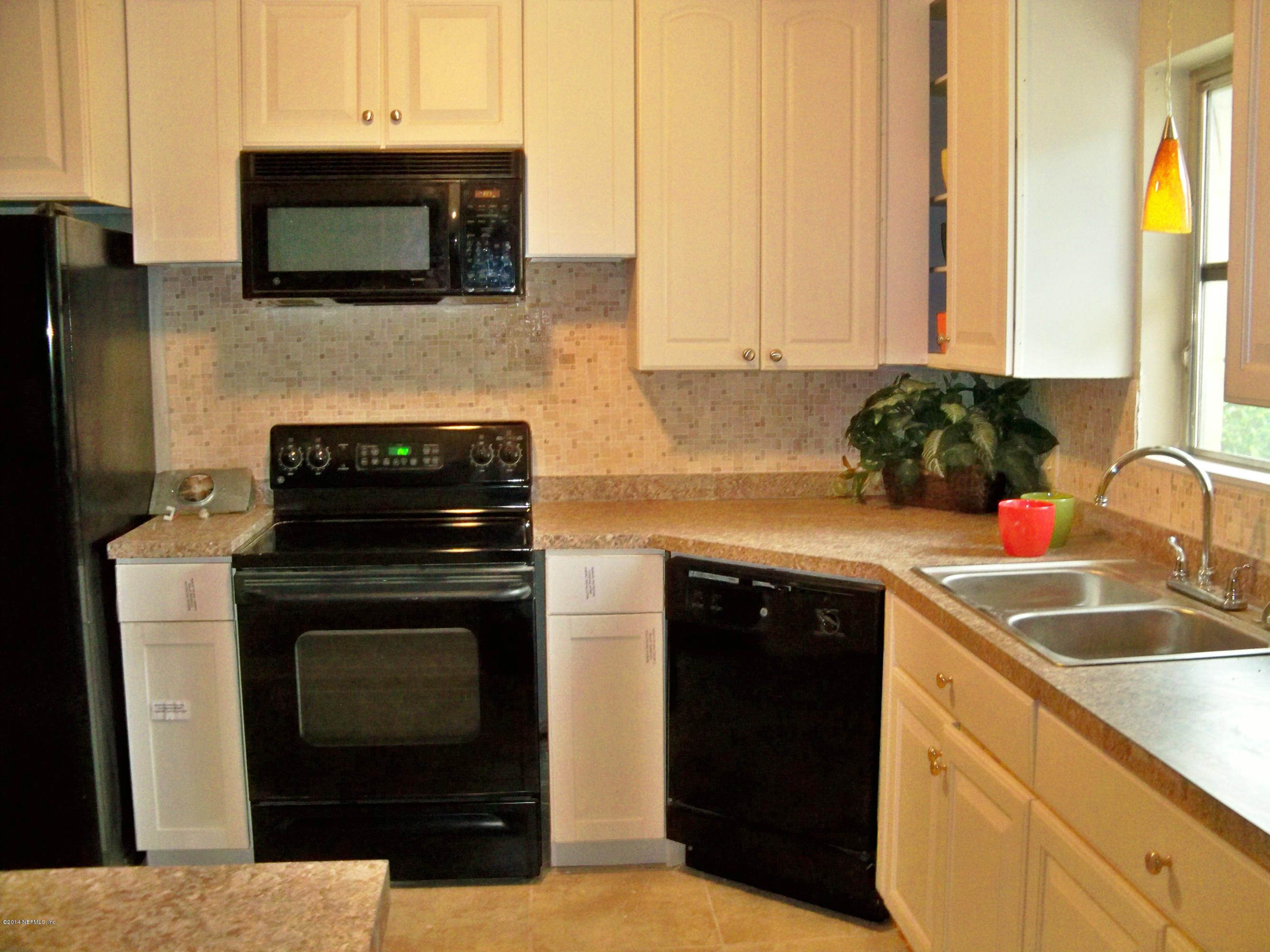 3219 Rogero Road Jacksonville, FL 32277 - Photo 6 of 13 a kitchen with a sink stove and microwave