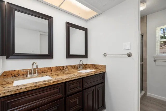a bathroom with a granite countertop sink two mirror and a