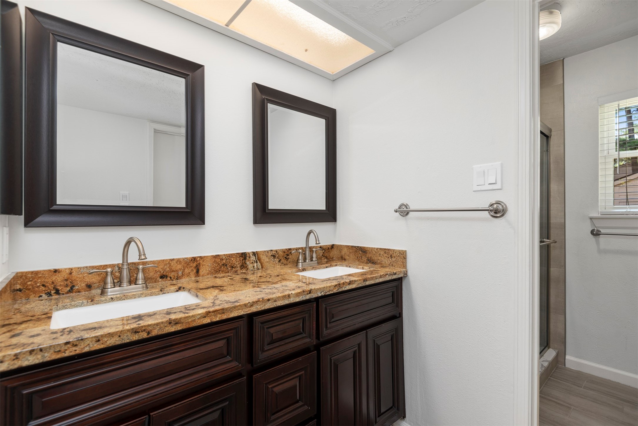 30 Berryfrost Lane The Woodlands, TX 77380 - Photo 19 of 33 a bathroom with a granite countertop sink two mirror and a