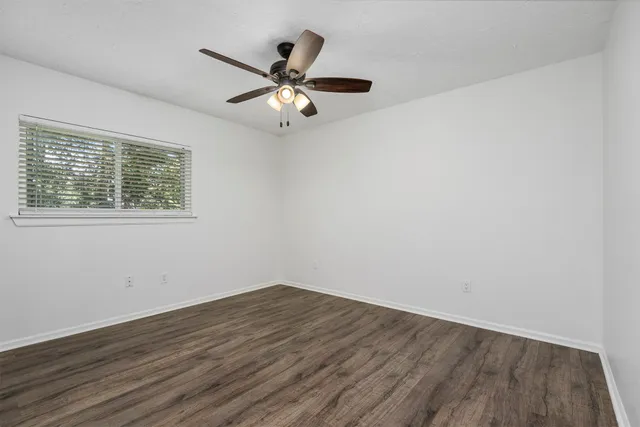 a view of a room with wooden floor and a ceiling fan
