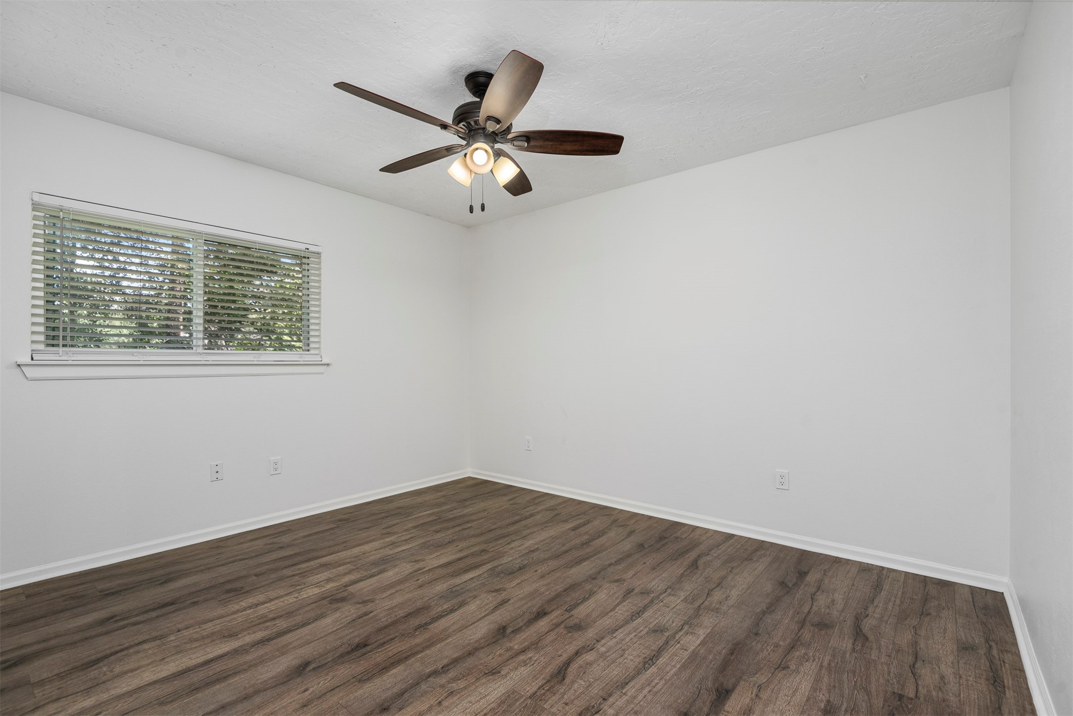 30 Berryfrost Lane The Woodlands, TX 77380 - Photo 24 of 33 a view of a room with wooden floor and a ceiling fan
