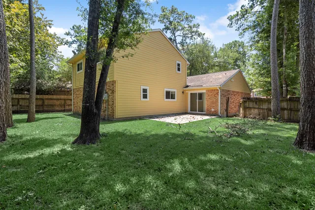 a view of a house with a backyard and a tree