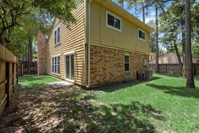 a view of a backyard with plants and large tree