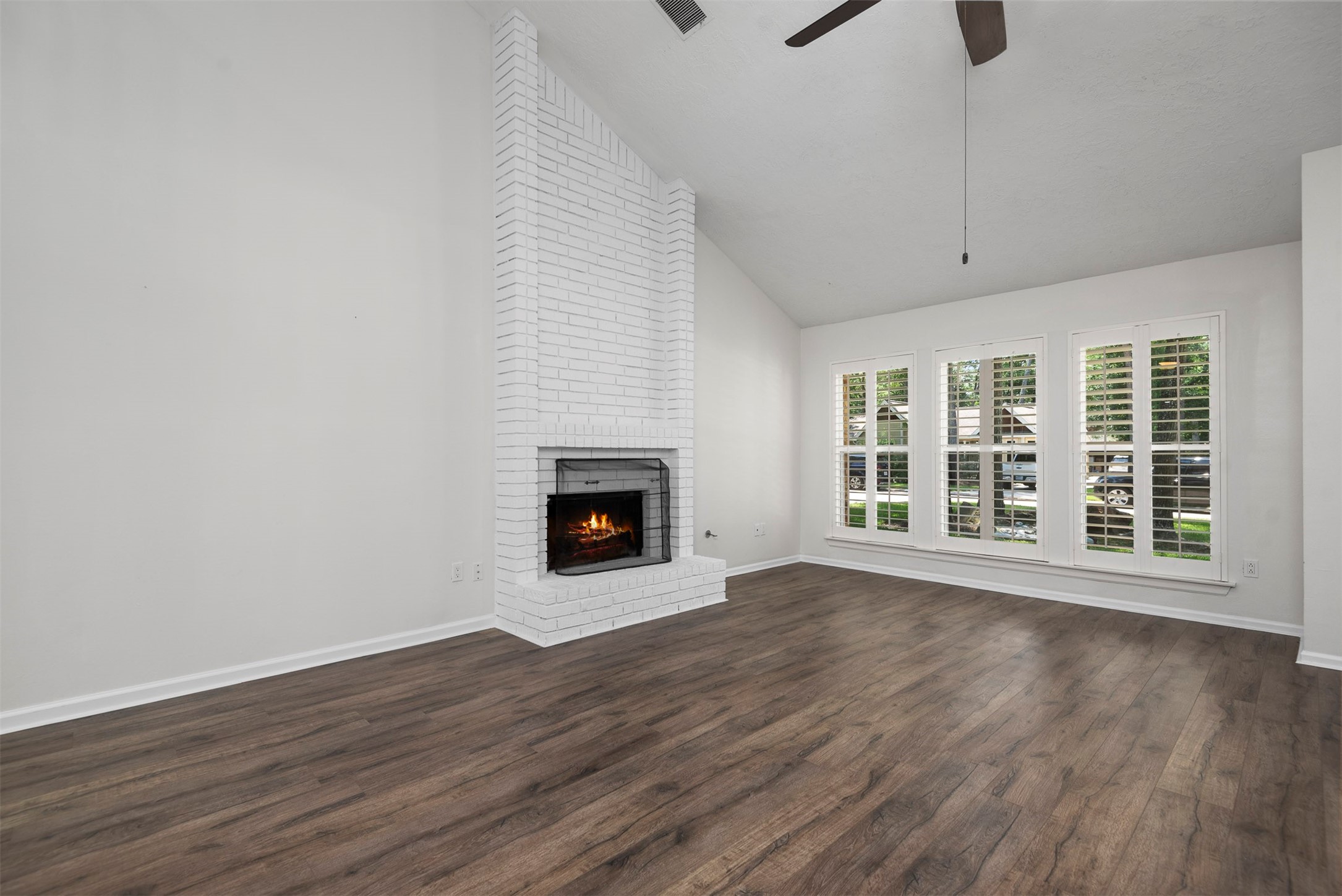 30 Berryfrost Lane The Woodlands, TX 77380 - Photo 5 of 33 a view of an empty room with wooden floor fireplace and a window