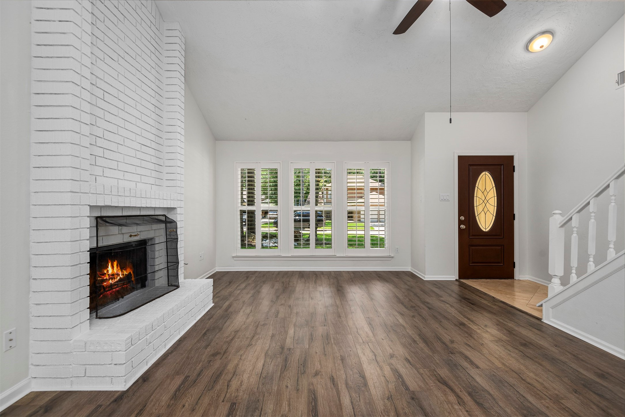 30 Berryfrost Lane The Woodlands, TX 77380 - Photo 6 of 33 a view of an empty room with wooden floor fireplace and a window