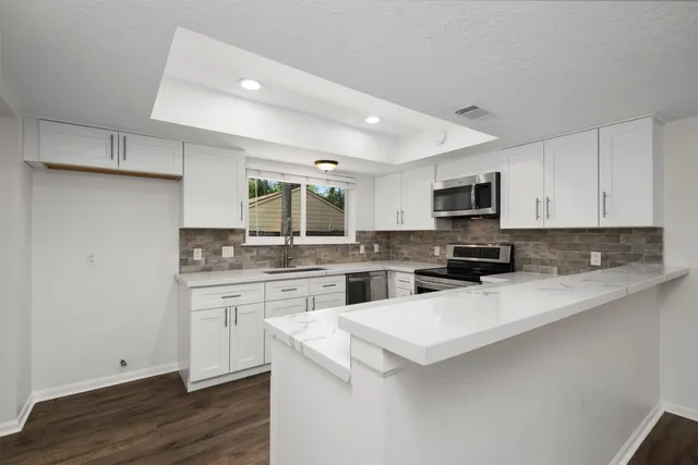 a kitchen with granite countertop white cabinets and white appliances