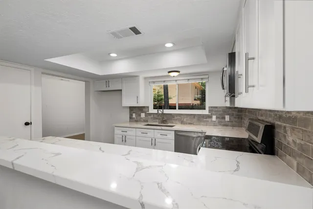 a large white bathroom with a large tub sink and double vanity