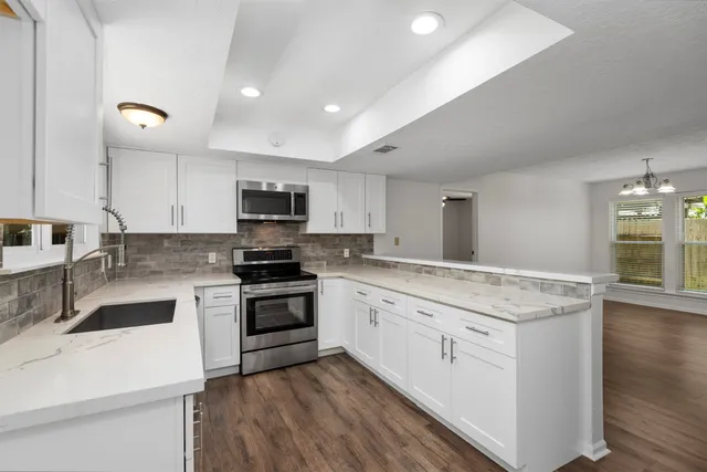 a kitchen with granite countertop stainless steel appliances and white cabinets
