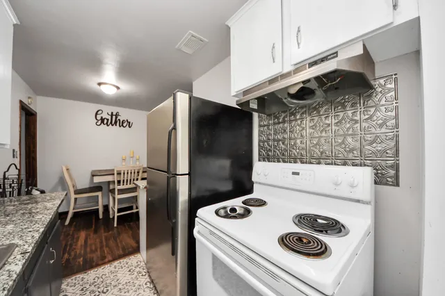 a kitchen with granite countertop a sink stainless steel appliances and cabinets