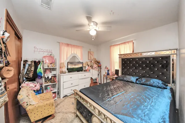 a bedroom with a bed and dresser with mirror