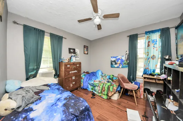 a bedroom with a bed and wooden floor