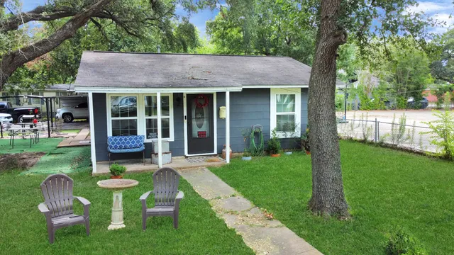 a view of a chair and table in backyard of the house