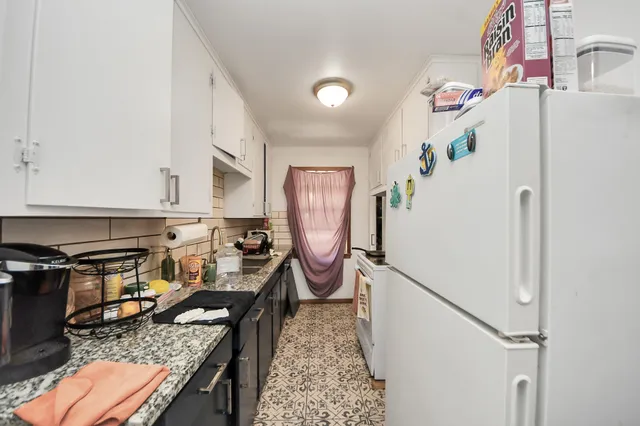 a kitchen with granite countertop a sink a stove and cabinets