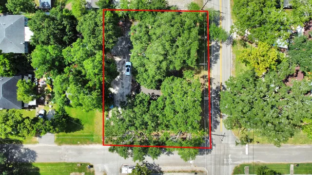 an aerial view of residential house with outdoor space and trees all around