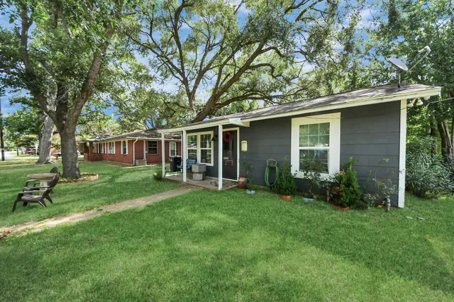 a view of house with a backyard