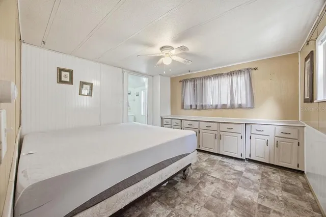 a spacious bedroom with a large bed and a chandelier