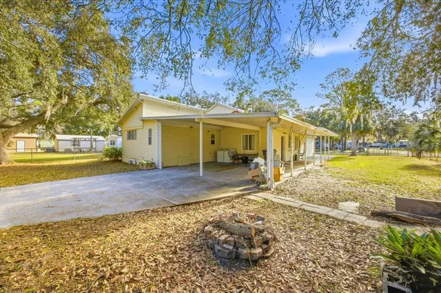 a view of a house with backyard and tree s