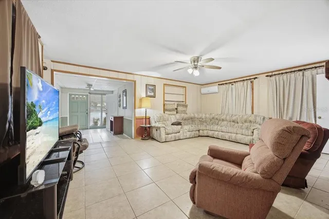 a living room with furniture a flat screen tv and a large window