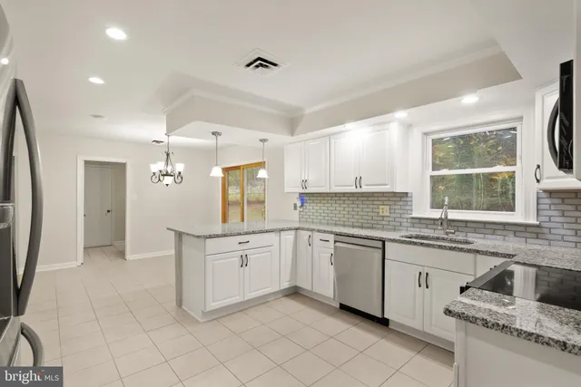 a kitchen with stainless steel appliances granite countertop a refrigerator and a stove top oven