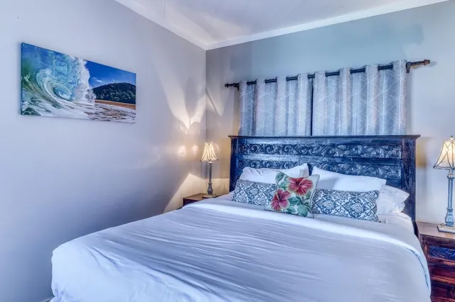 a bed sitting in a bedroom and painting on the wall