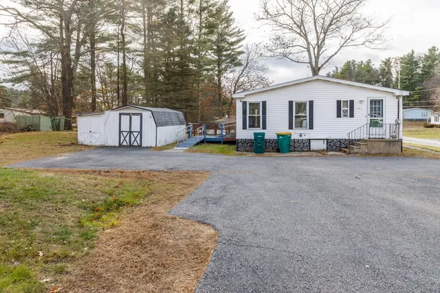 a view of a house with backyard and a tree