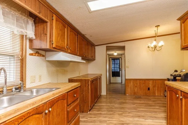 a large kitchen with stainless steel appliances granite countertop a sink and cabinets