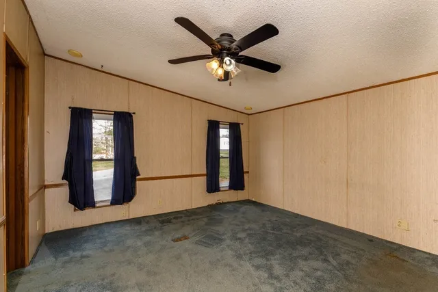 a view of an empty room with ceiling fan