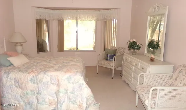 a spacious bedroom with a bed and a large mirror next to a window