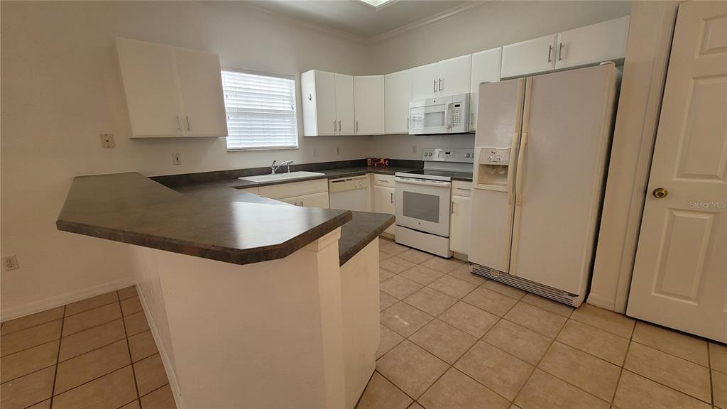 4926 Northwest 78 Road Gainesville, FL 32653 - Photo 4 of 18 a kitchen with granite countertop white cabinets and white appliances