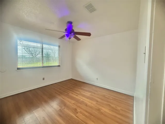 an empty room with a window and a fan