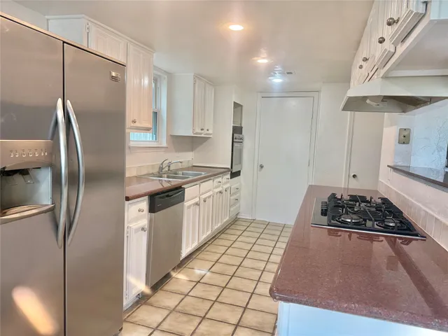 a kitchen with stainless steel appliances granite countertop a refrigerator and a stove