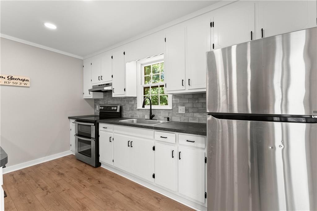 31 Pine Road Dahlonega, GA 30533 - Photo 12 of 32 a kitchen with granite countertop a refrigerator a sink a stove and white cabinets
