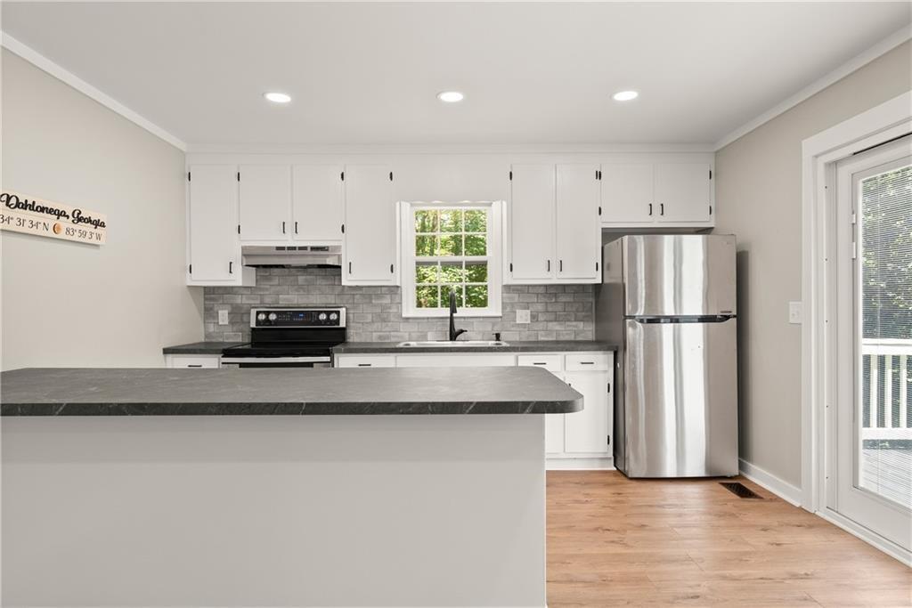 31 Pine Road Dahlonega, GA 30533 - Photo 13 of 32 a kitchen with kitchen island granite countertop white cabinets and refrigerator