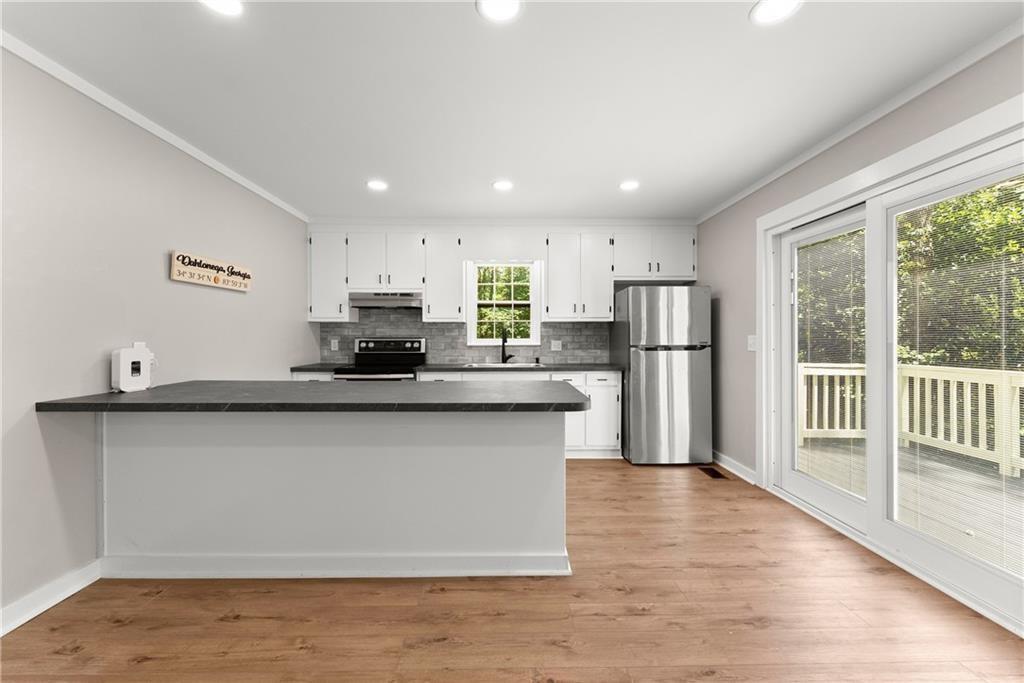 31 Pine Road Dahlonega, GA 30533 - Photo 14 of 32 a kitchen with stainless steel appliances granite countertop a refrigerator a sink dishwasher a stove and white cabinets with wooden floor