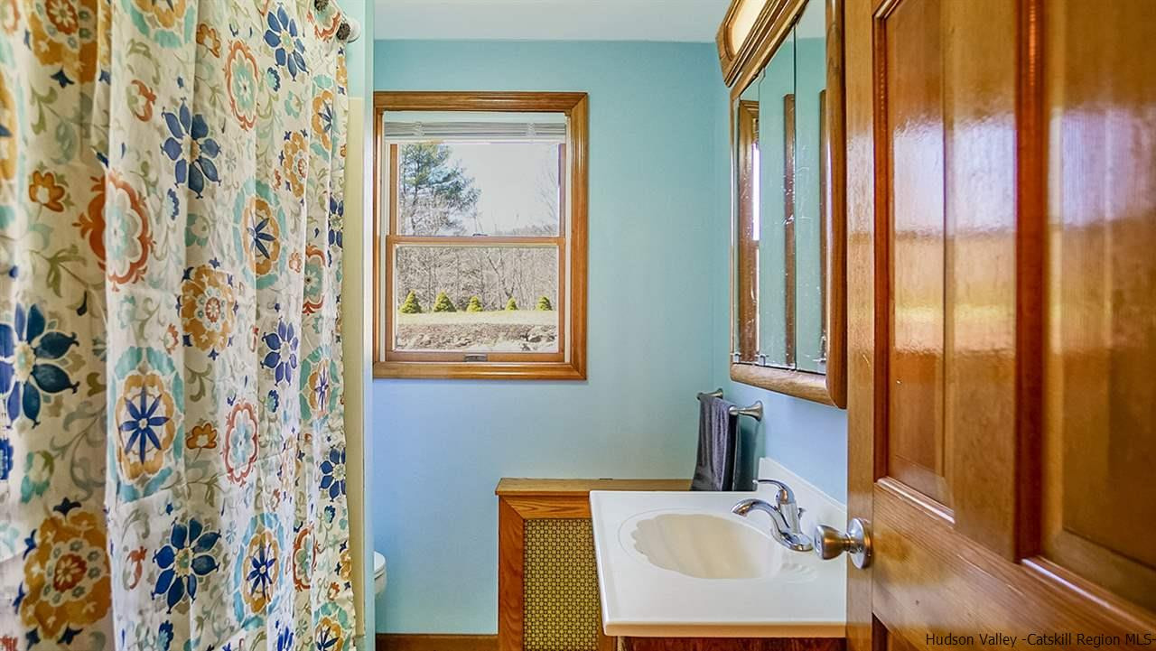 124 Wilhelm Road Saugerties, NY 12477 - Photo 21 of 33 a bathroom with a sink a mirror and a shower curtain