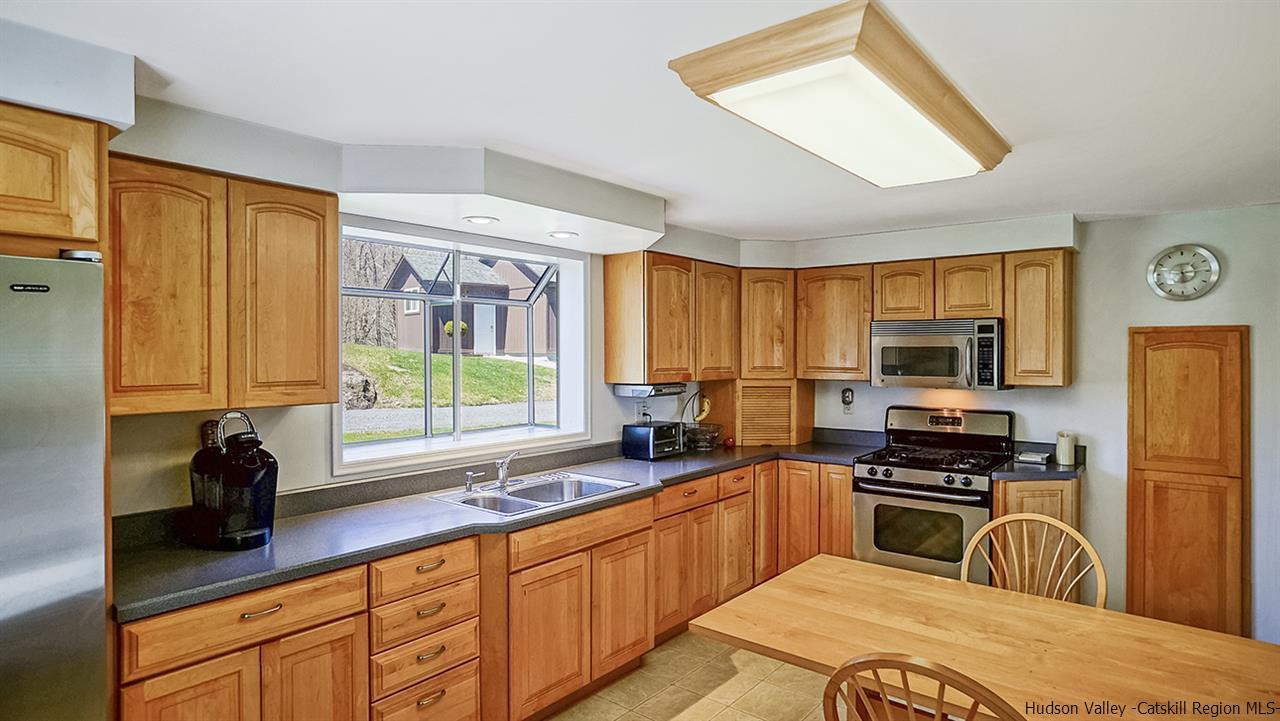 124 Wilhelm Road Saugerties, NY 12477 - Photo 6 of 33 a kitchen with granite countertop a stove a sink and a refrigerator