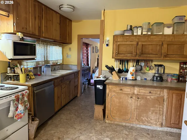 a kitchen with granite countertop a sink stove and cabinets