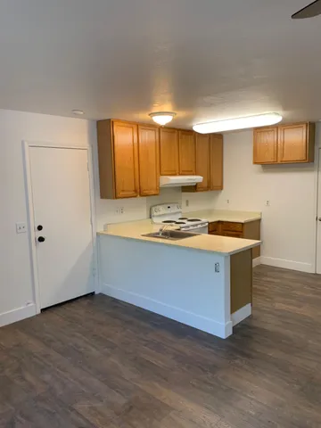 a kitchen with stainless steel appliances granite countertop a sink a stove and a wooden floors