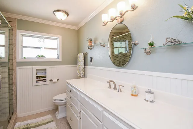 a bathroom with a toilet a sink and mirror