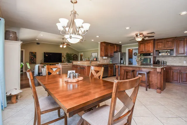 a dining area with a table chairs and a kitchen view