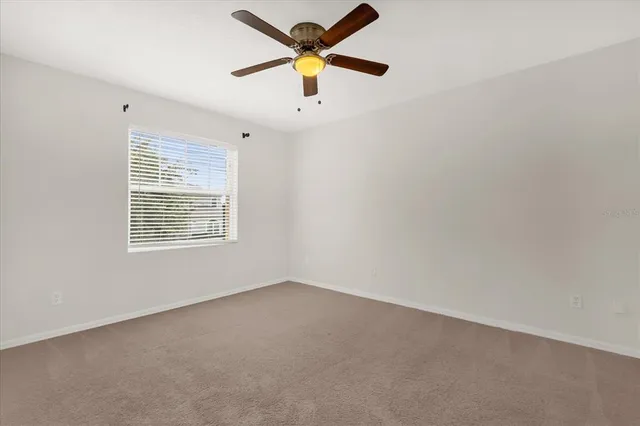 an empty room with a window and a fan