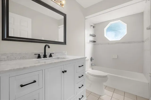 a bathroom with a toilet a sink a mirror and a bathtub