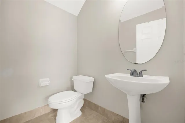a bathroom with a sink a toilet and mirror