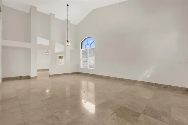 an empty room with windows and ceiling fan