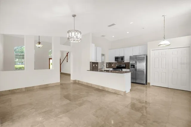 a view of a kitchen with refrigerator and window