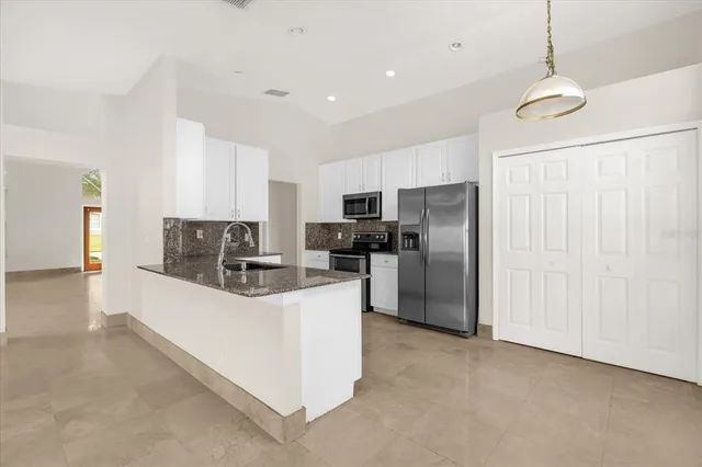 a kitchen with stainless steel appliances a refrigerator and a stove top oven