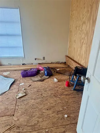 a view of a workspace with wooden floor and a window