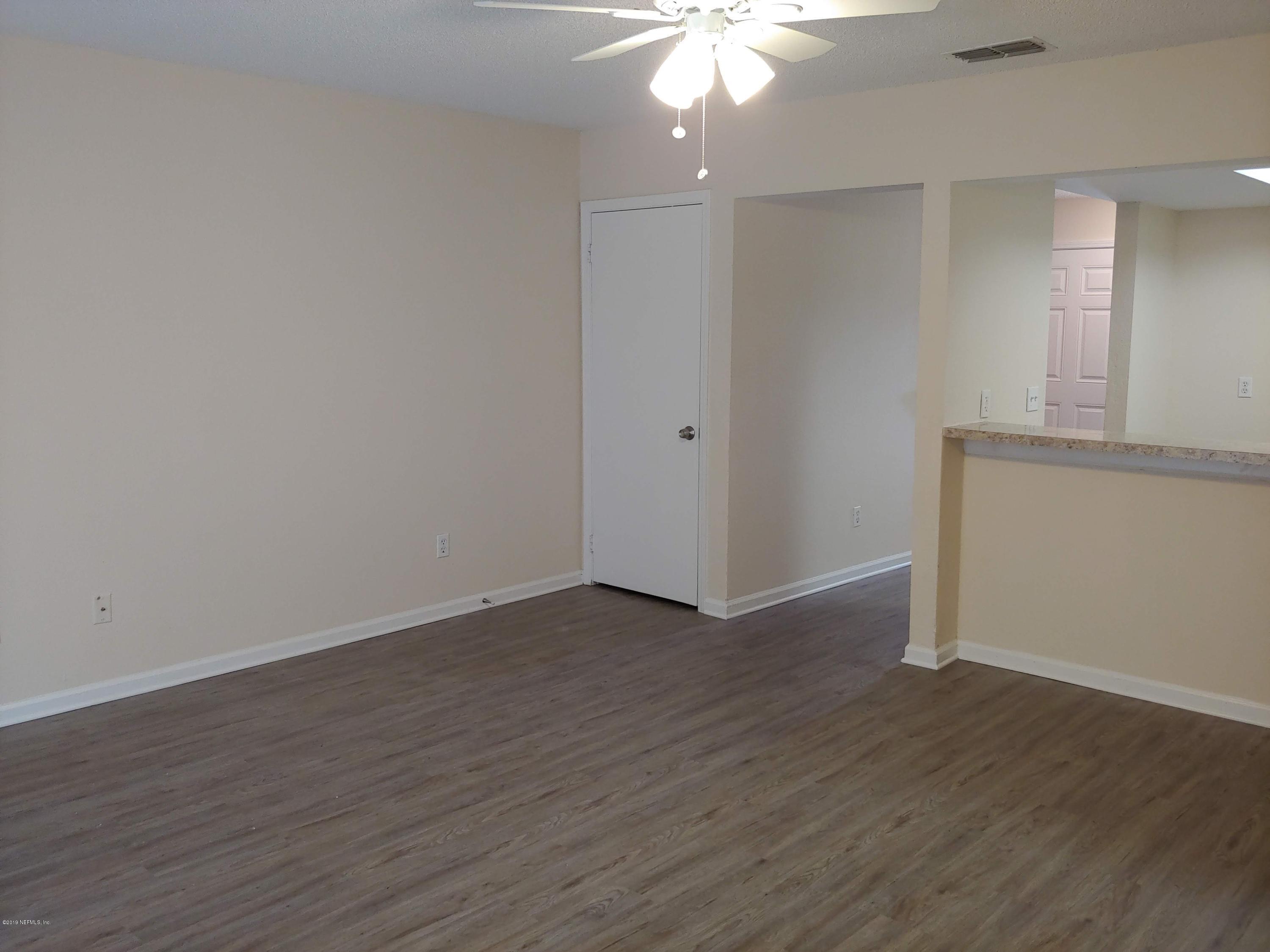 791 Assisi Lane, Unit 303 Jacksonville, FL 32233 - Photo 18 of 35 an empty room with wooden floor and chandelier fan