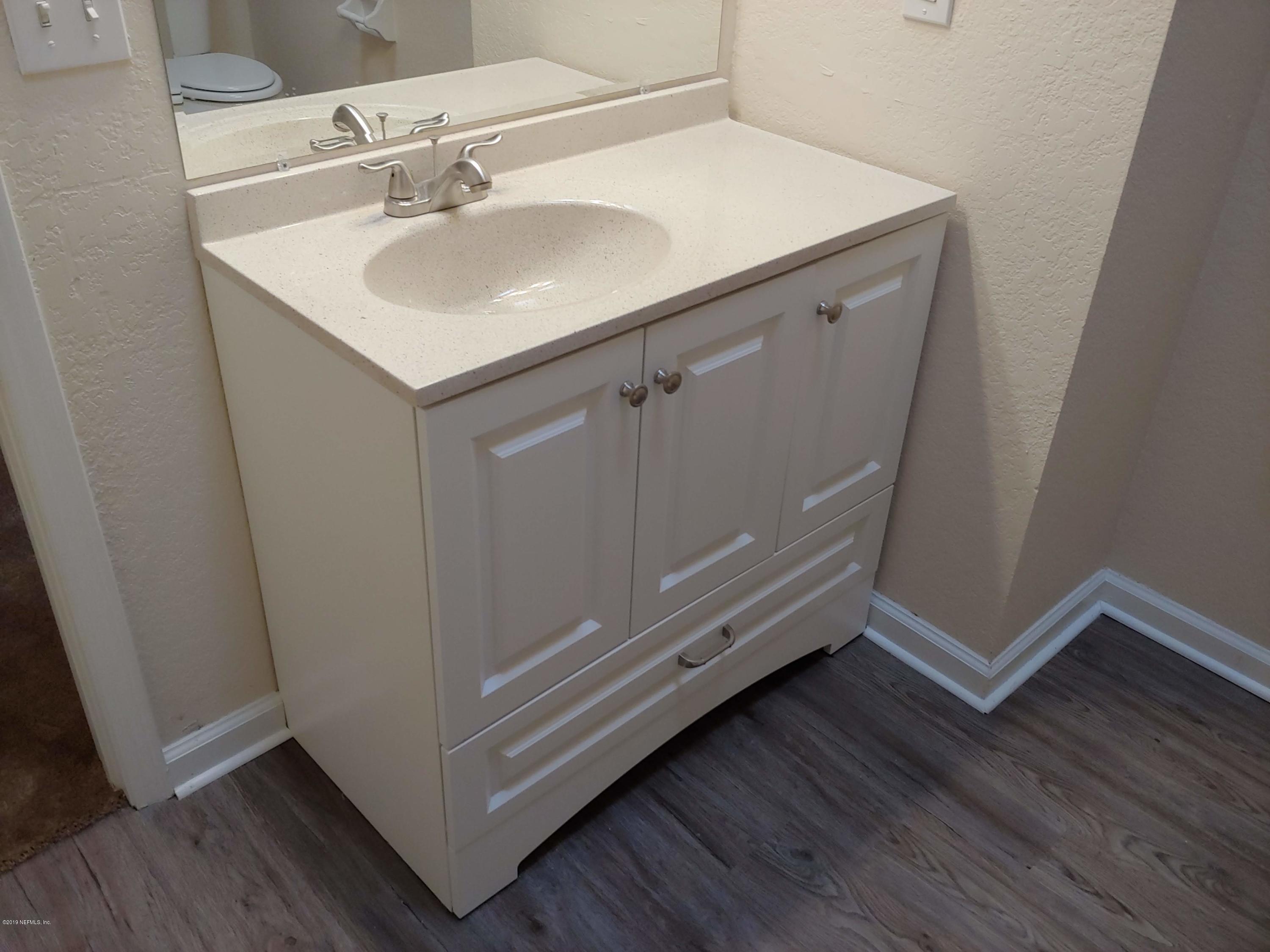 791 Assisi Lane, Unit 303 Jacksonville, FL 32233 - Photo 22 of 35 a bathroom with a sink and a mirror