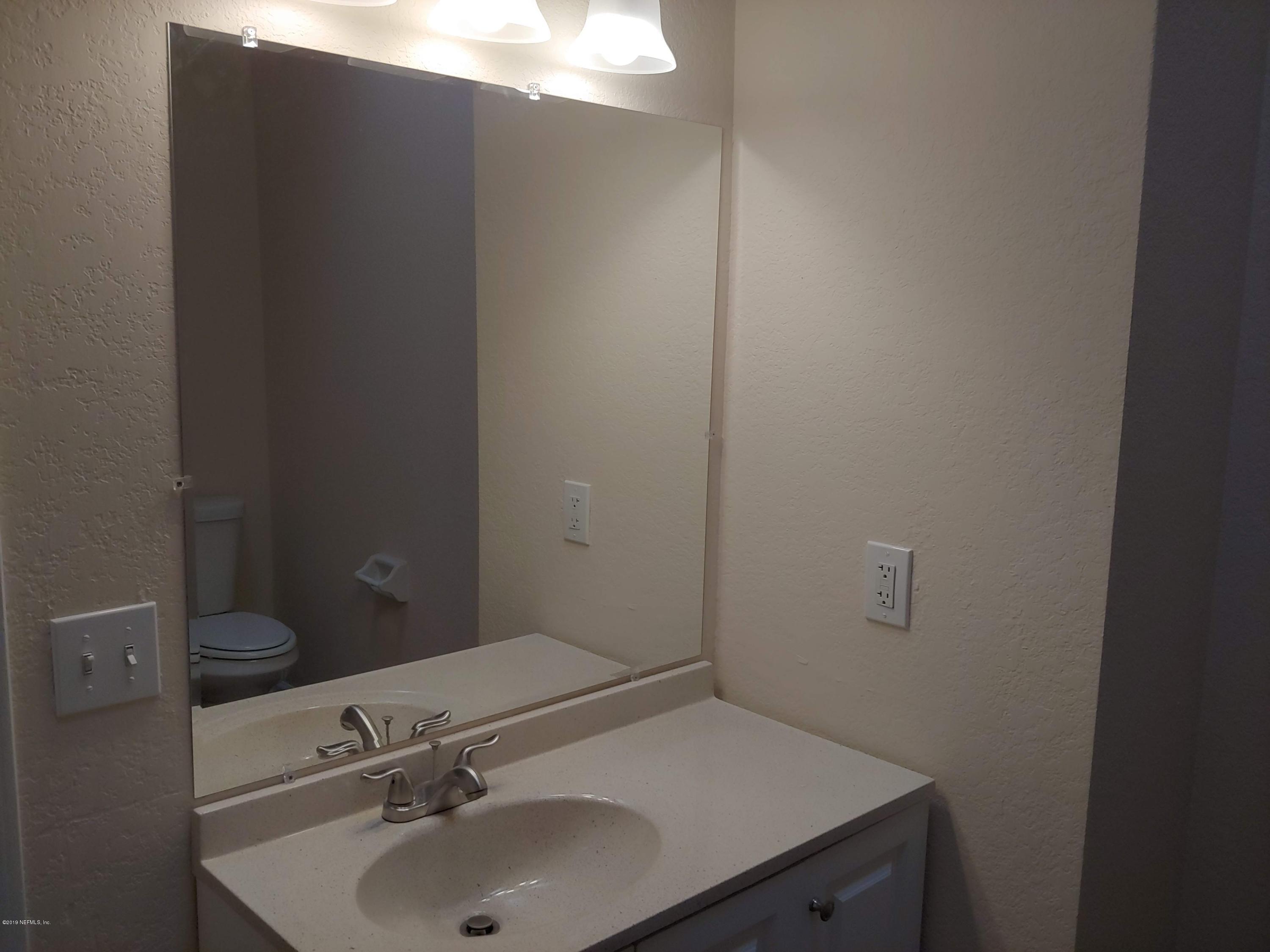 791 Assisi Lane, Unit 303 Jacksonville, FL 32233 - Photo 23 of 35 a bathroom with a sink and mirror